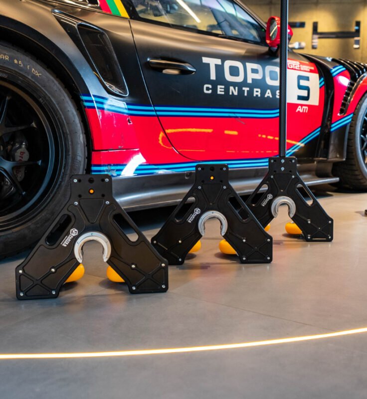 NP Air Jack skates in use next to Porsche GT2 RS race car – motorsport pit equipment for fast wheel change