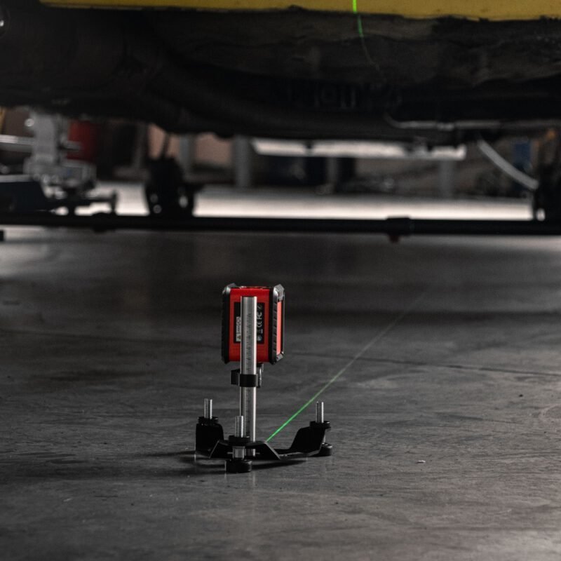 NP laser alignment stand with green laser beam under race car – adjustable laser level for motorsport wheel alignment