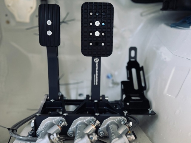 NP Parts floor-mounted Pedalbox with Wilwood master cylinders, front view in white race car interior