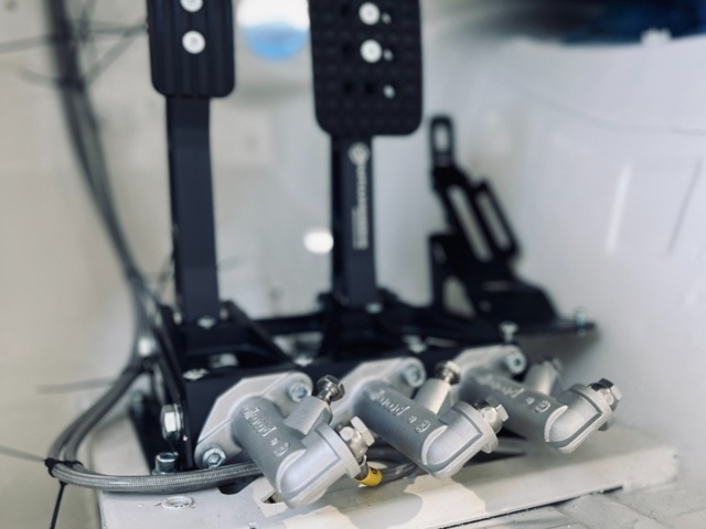 NP Parts Pedalbox installed in race car footwell showing three Wilwood master cylinders