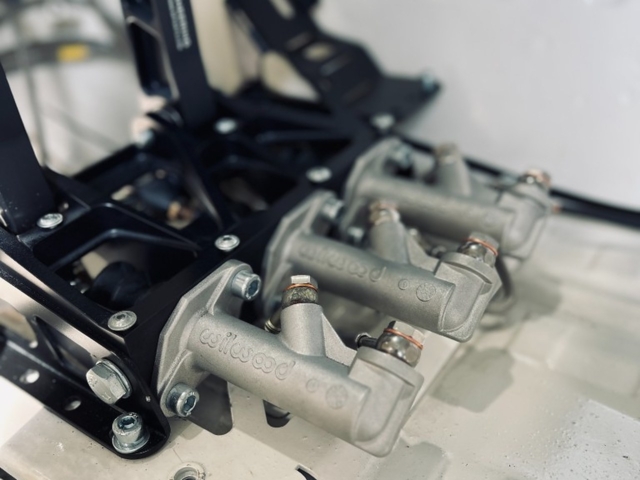 Close-up of Wilwood master cylinders on NP Parts Pedalbox with NP Parts branding on pedal arm